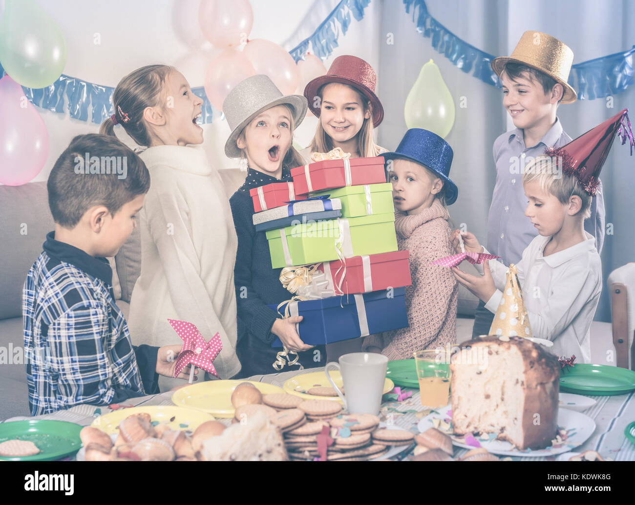 Felici i bambini presentando doni alla bambina durante la festa di compleanno Foto Stock