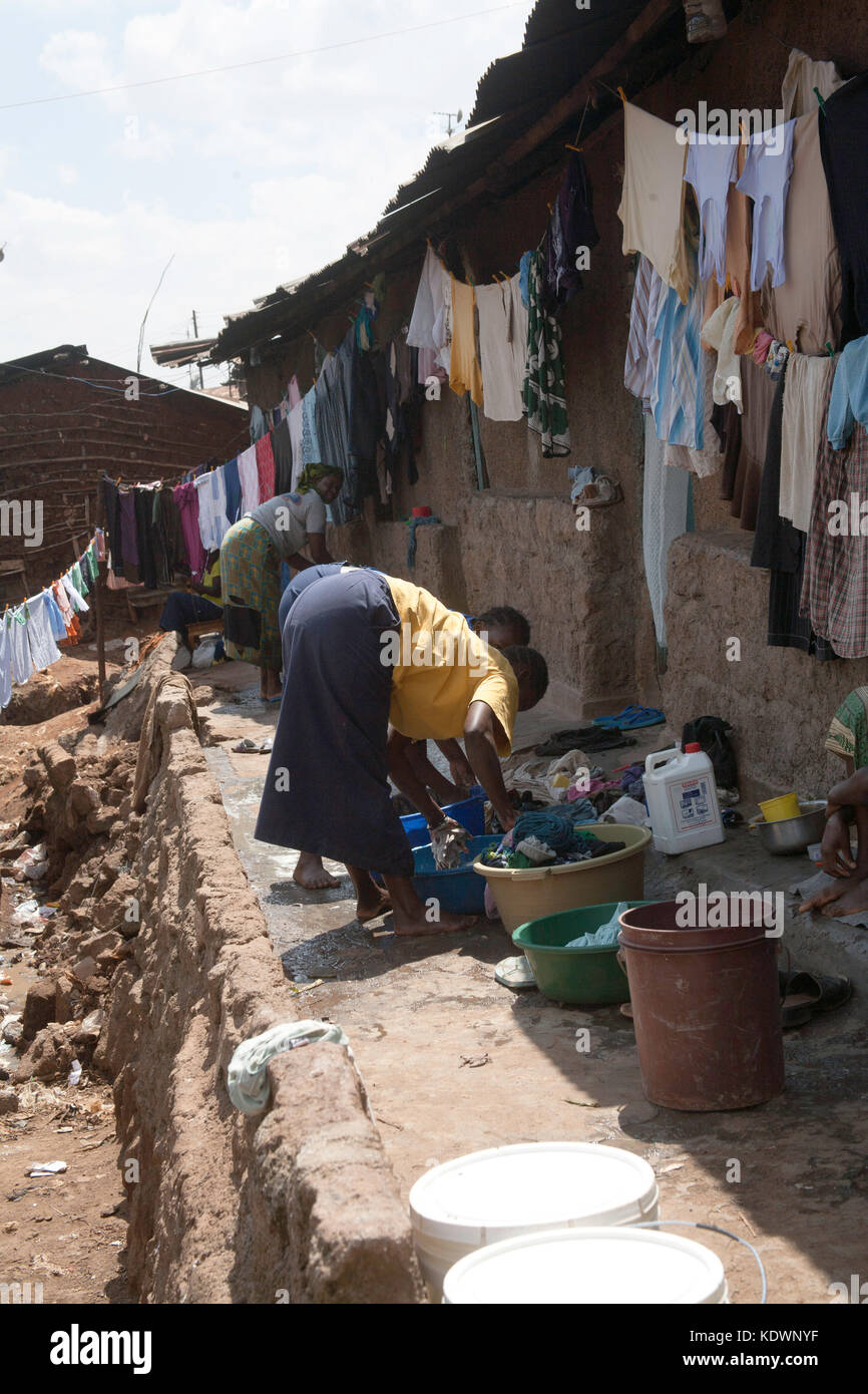 Donne che lavano vestiti in Kibera slum, Nairobi, Kenia, Africa orientale Foto Stock