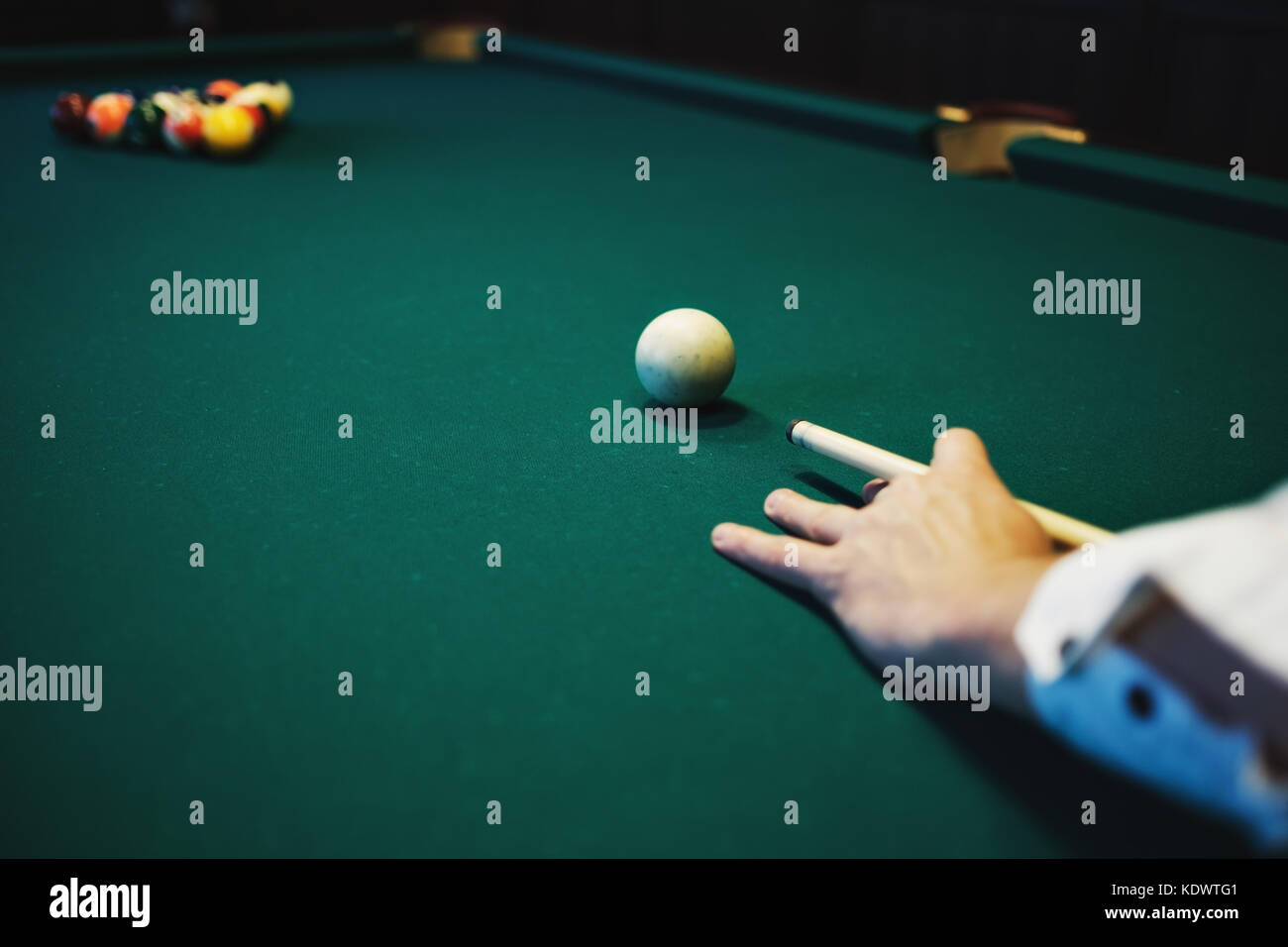 Biliardo americano. L'uomo giocando a biliardo, snooker. Il giocatore si prepara a sparare e a colpire la bilia battente. Foto Stock