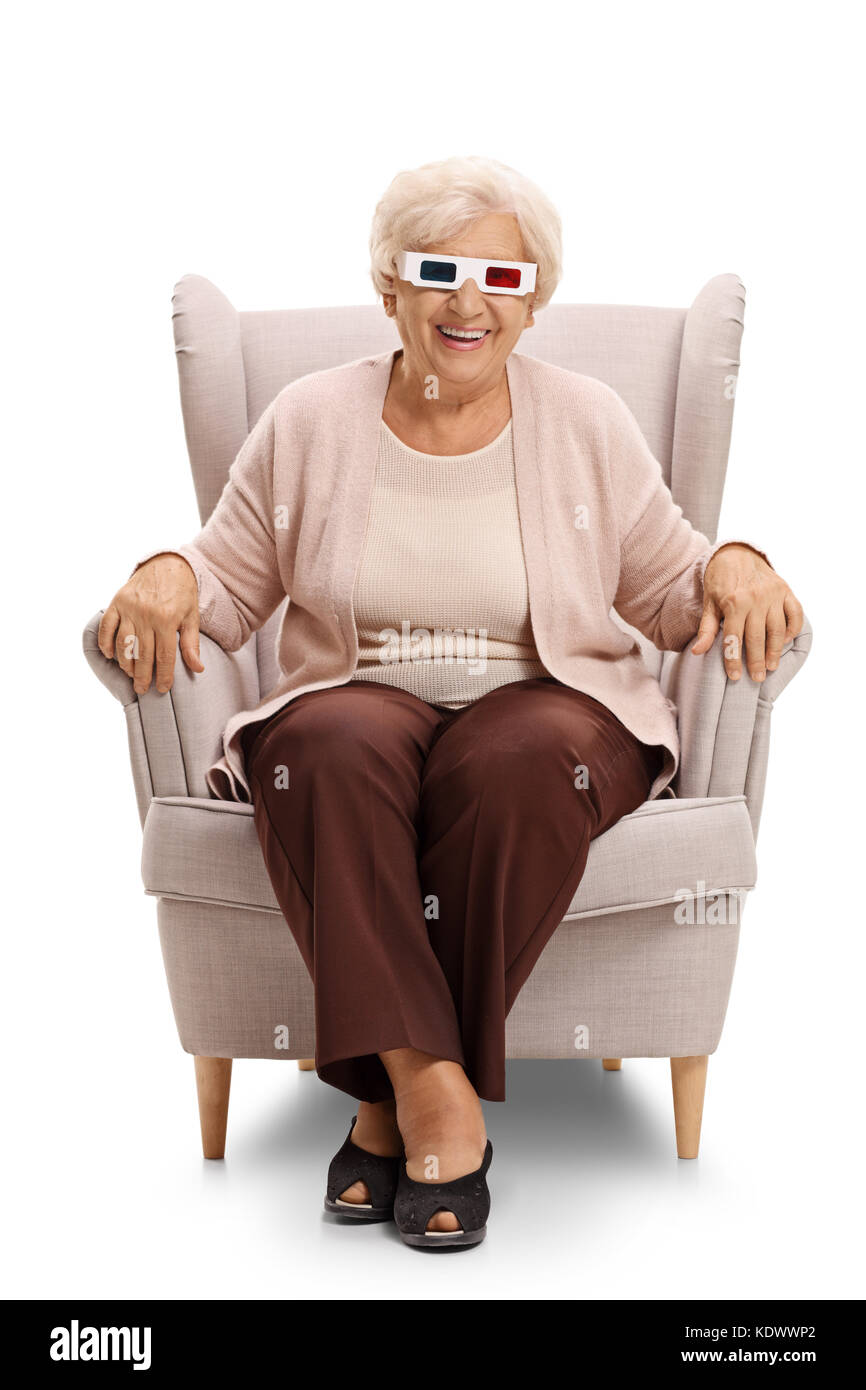 Donna matura con un paio di occhiali 3d seduto in poltrona e guardando la telecamera isolata su sfondo bianco Foto Stock