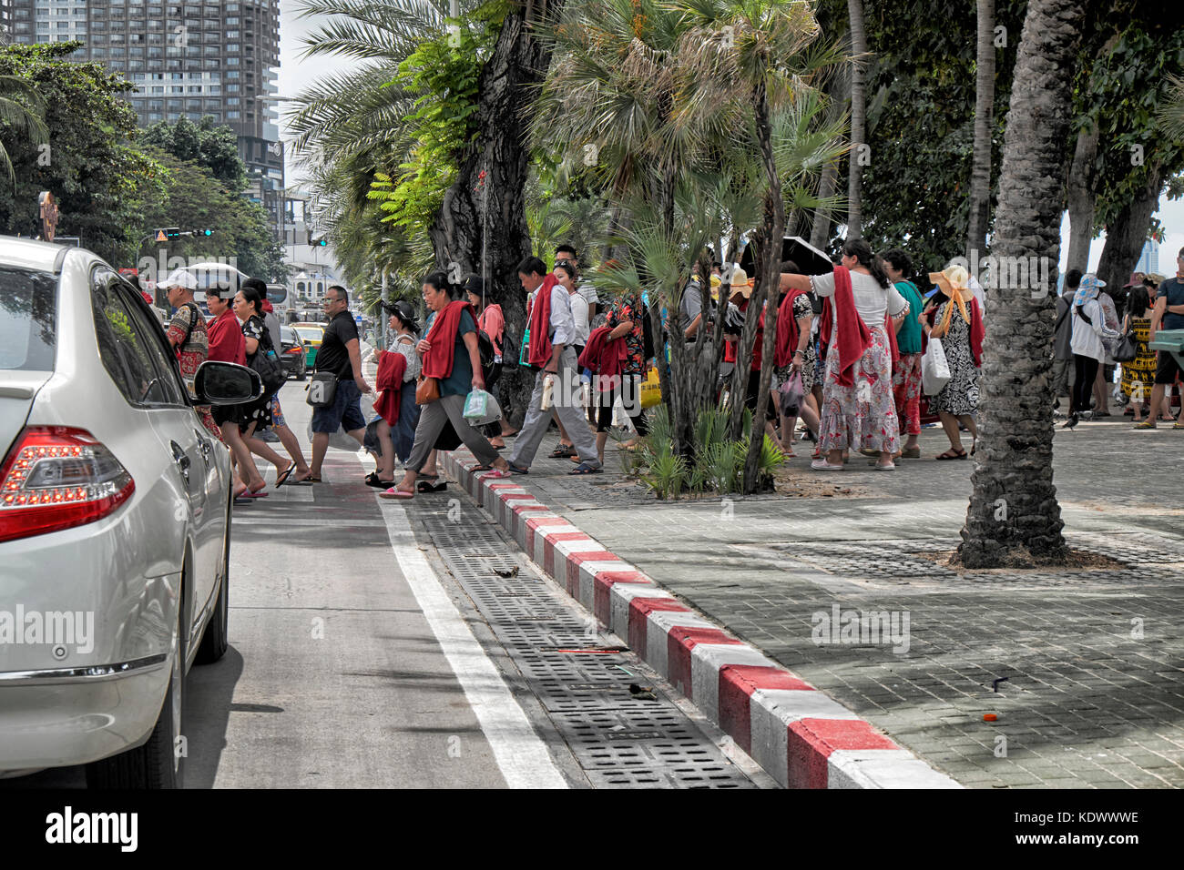 Un folto gruppo di turisti cinesi che attraversa la strada. Pattaya street scene, Thailandia del sud-est asiatico. Le persone che attraversano le road. Pattaya beach road Foto Stock