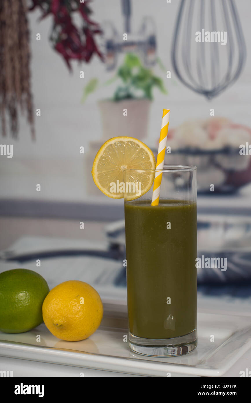 Salute verde drink frullato guarnita con limoni e limette. Foto Stock