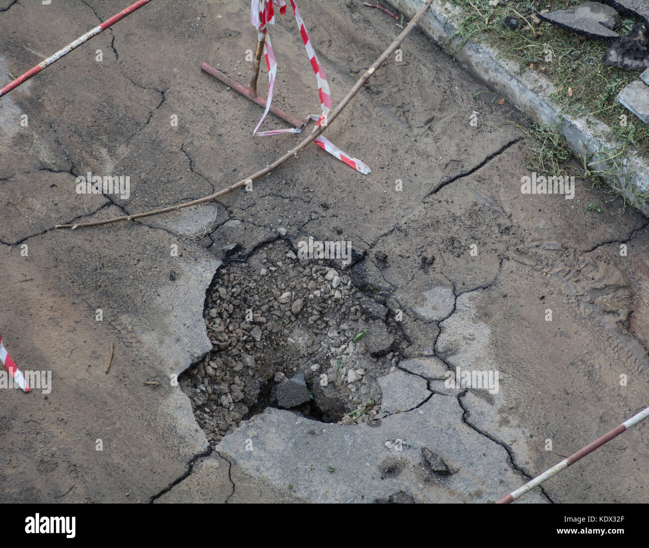 Un foro in asfalto nel cortile di una zona residenziale. Strada danneggiata Foto Stock
