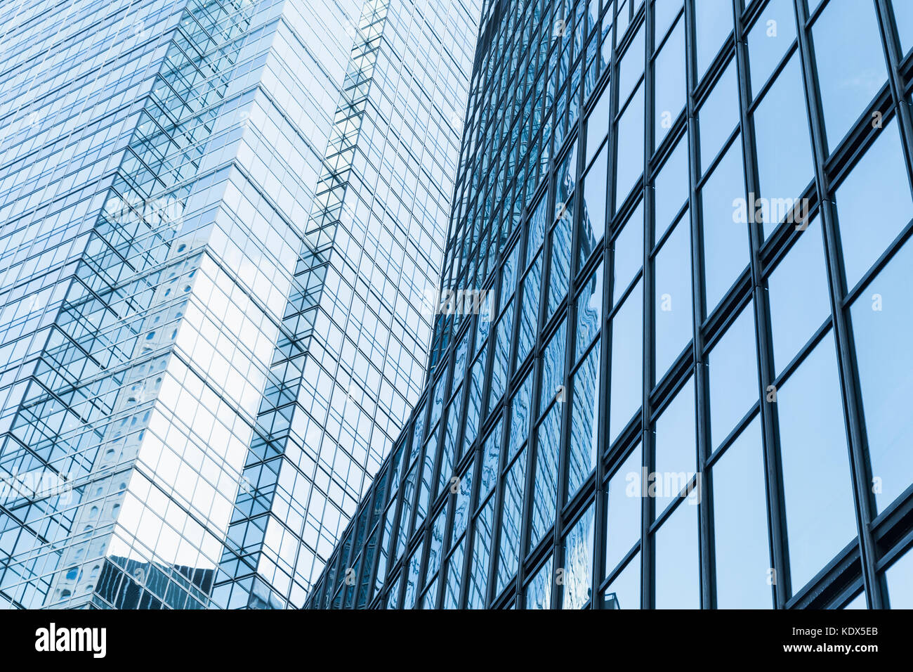 Abstract moderna architettura business frammento, e le pareti in vetro e acciaio con riflessi di colore blu cielo nuvoloso Foto Stock