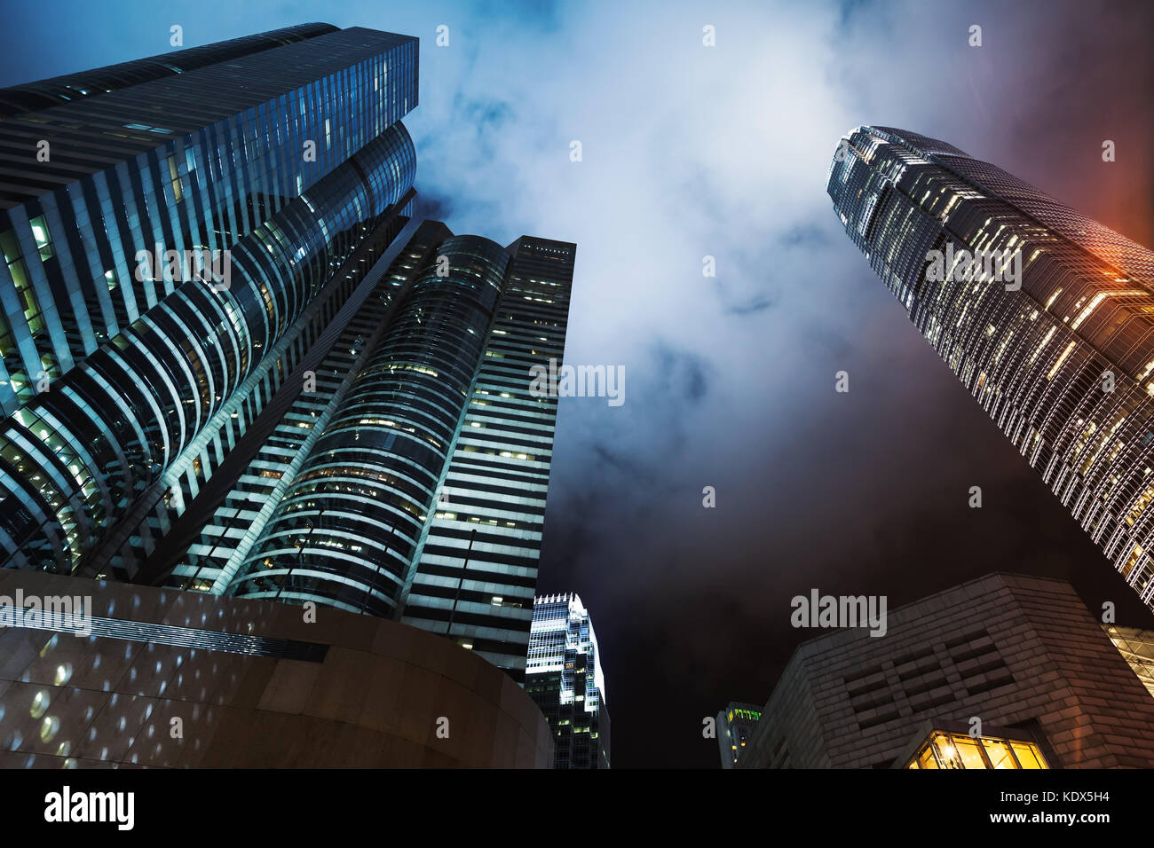 Lo skyline di notte con grattacieli sotto il cielo nuvoloso, alto-aumento edifici per uffici a Hong kong city Foto Stock