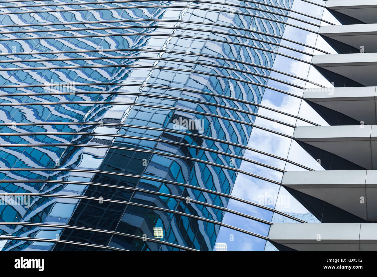 Abstract ufficio moderno edificio frammento di architettura, le pareti di vetro e acciaio con riflessi di colore blu cielo nuvoloso Foto Stock
