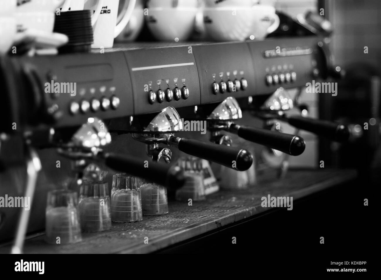 Macchine per il caffè preso in una caffetteria locale in bianco e nero Foto Stock