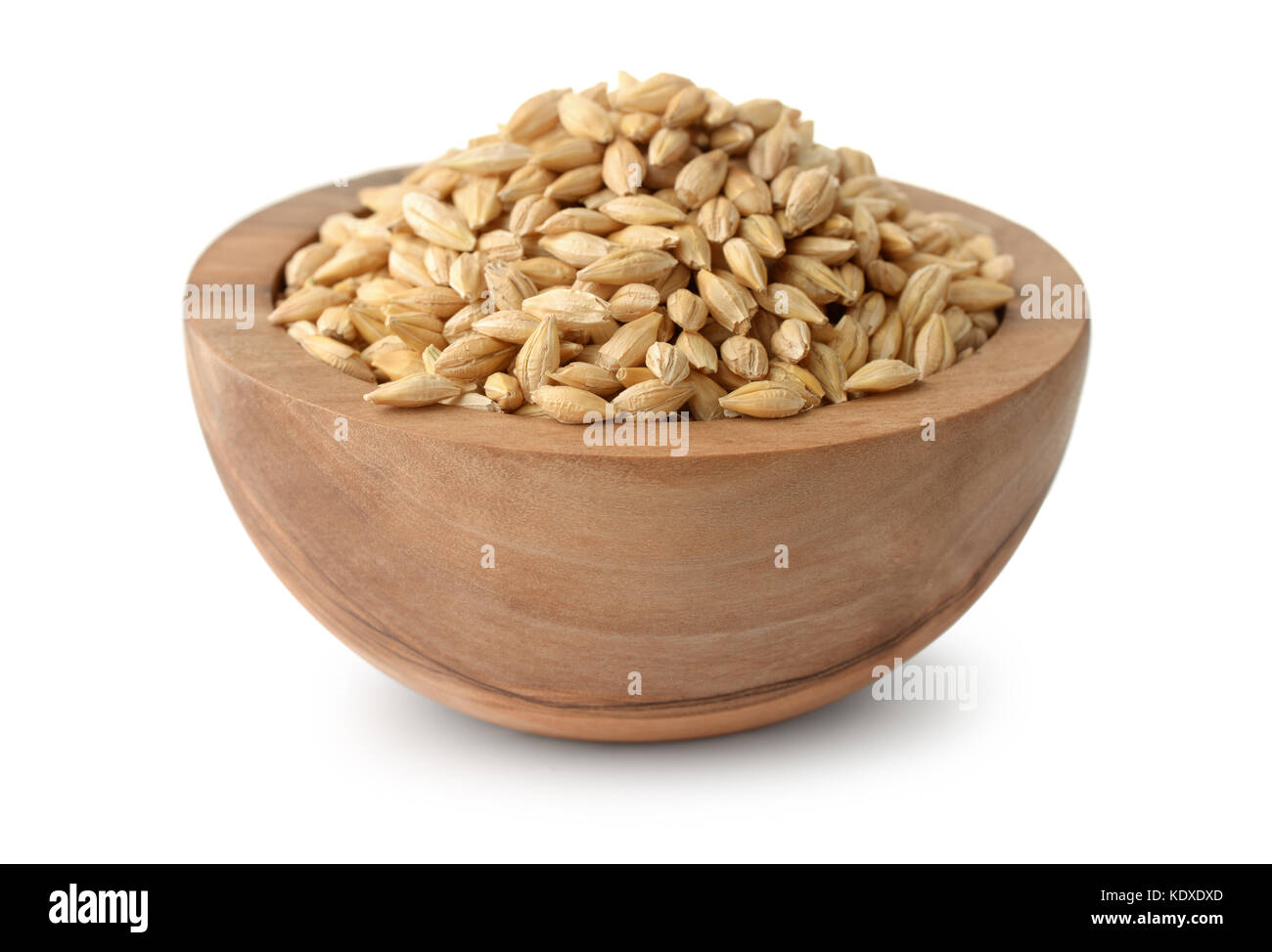 Ciotola di legno di chicchi d'orzo isolato su bianco Foto Stock