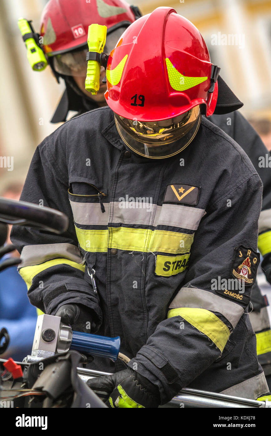 Zamość/POLONIA - agosto 13,2017: vigili del fuoco lavorando su un veicolo automatico extrication con una potenza idraulica strumento di salvataggio. lettere straz significa vigile del fuoco Foto Stock