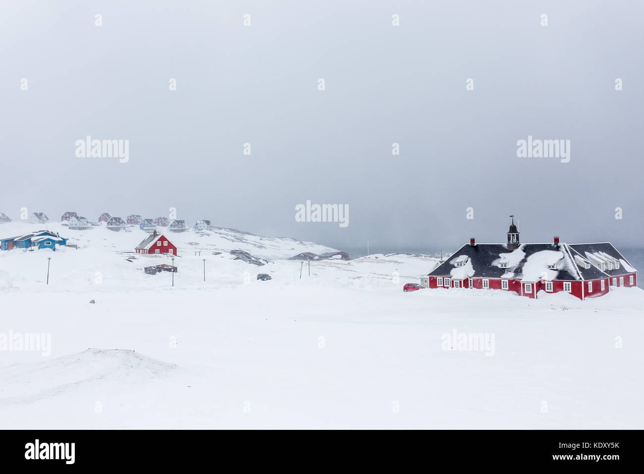 Il vecchio edificio rosso e case inuit in background tra la neve a fiordo, nuuk Groenlandia Foto Stock