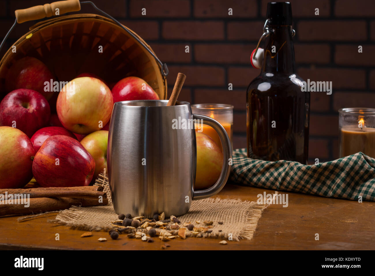 Boccale in argento con il sidro di mele con un versamento cesto in legno di mele in background Foto Stock