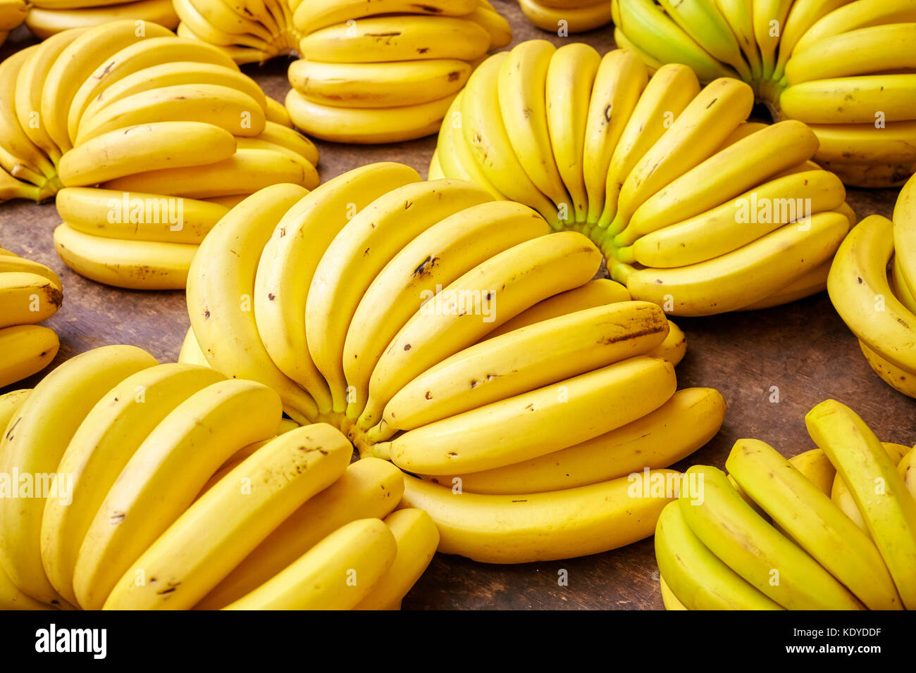 Naturale organico maturo banana grappoli su un mercato locale, il fuoco selettivo. Foto Stock