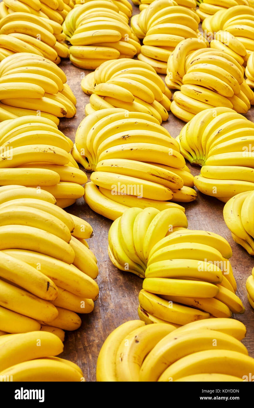Naturale organico maturo banana grappoli su un mercato locale, il fuoco selettivo. Foto Stock
