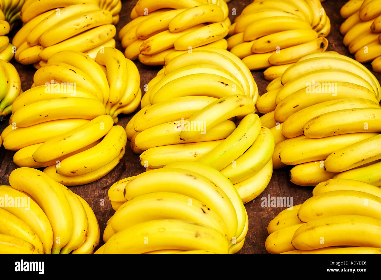 Naturale organico maturo banana grappoli su un mercato locale, il fuoco selettivo. Foto Stock