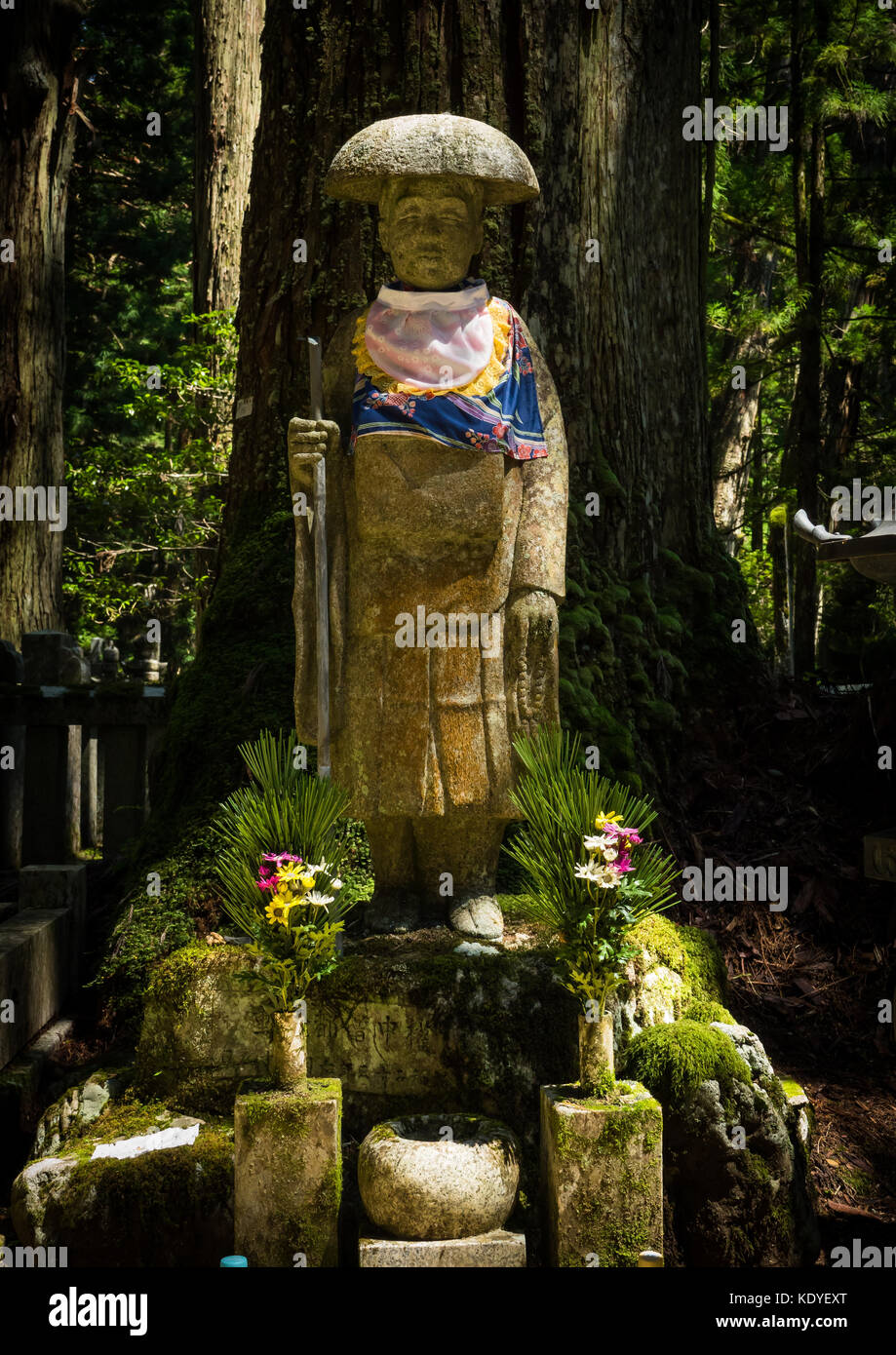 Decorate Jizo statua in presenza di luce solare con offerte presso il cimitero di Okunoin, Koya-San prefettura di Wakayama, Giappone Foto Stock