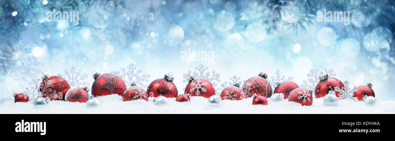 Natale - decorate palle rosse e fiocchi di neve sulla neve Foto Stock