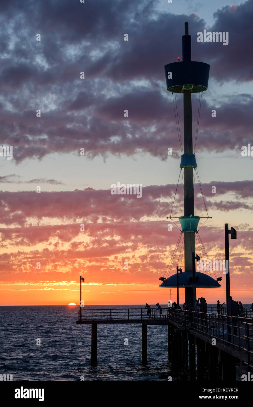 Le persone godono di un magnifico tramonto al mare di Adelaide del molo di Brighton su una mite serata d'estate. Foto Stock