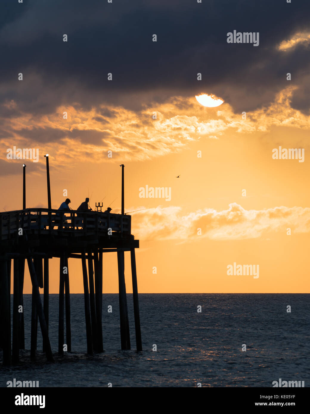 Pescatore per tentare la fortuna poco dopo l'alba a avon molo pesca su hatteras island, North Carolina. Foto Stock