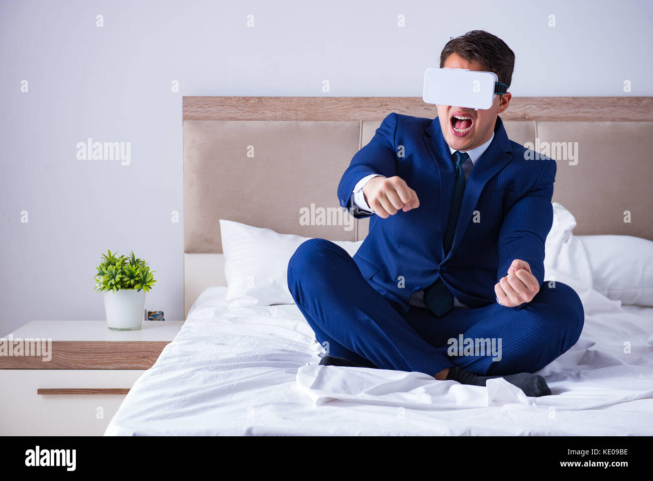 Imprenditore indossando una realtà virtuale auricolare in camera da letto Foto Stock