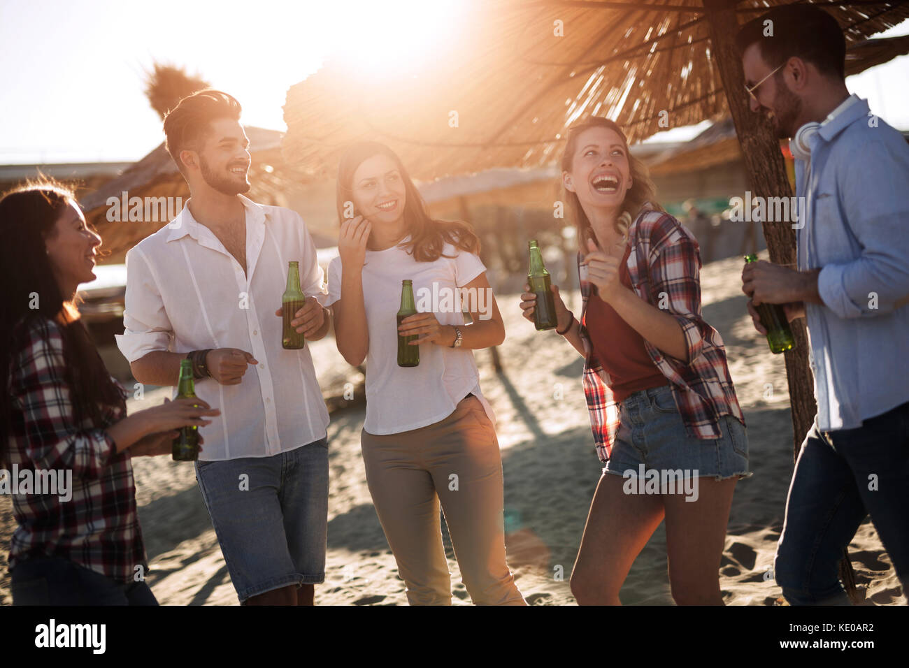 Un gruppo di giovani amici di ridere e bere birra Foto Stock