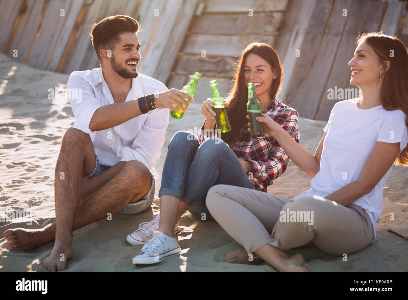 Un gruppo di giovani amici di ridere e bere birra Foto Stock