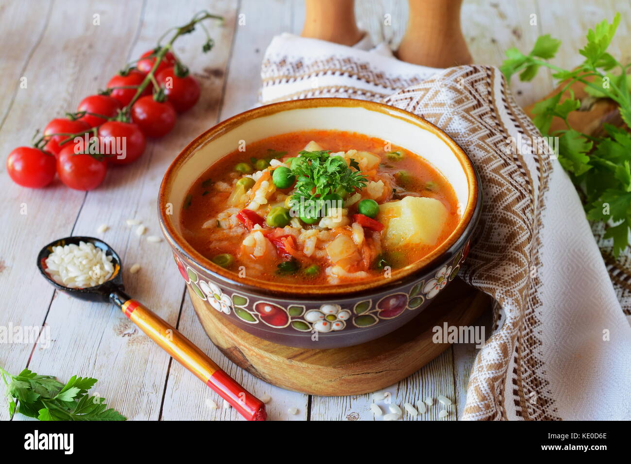 Minestra di verdura con riso, pomodoro, patata, i piselli, carote e cipolle. Il mangiare sano concetto Foto Stock