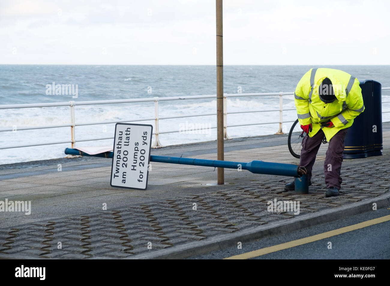 Aberystwyth Galles Regno Unito, martedì 17 ottobre 2017 Regno Unito Meteo: al primo semaforo della mattina dopo l'assalto dell'ex uragano Ophelia, i lavoratori delle autorità locali che indossano giacche gialle ad alta visibilità valutano e mettono al sicuro alcuni dei danni causati dai cartelli stradali sul lungomare di Aberystwyth, sulla costa di Cardigan Bay, nel galles occidentale. foto: Keith Morris/Alamy Live News Foto Stock