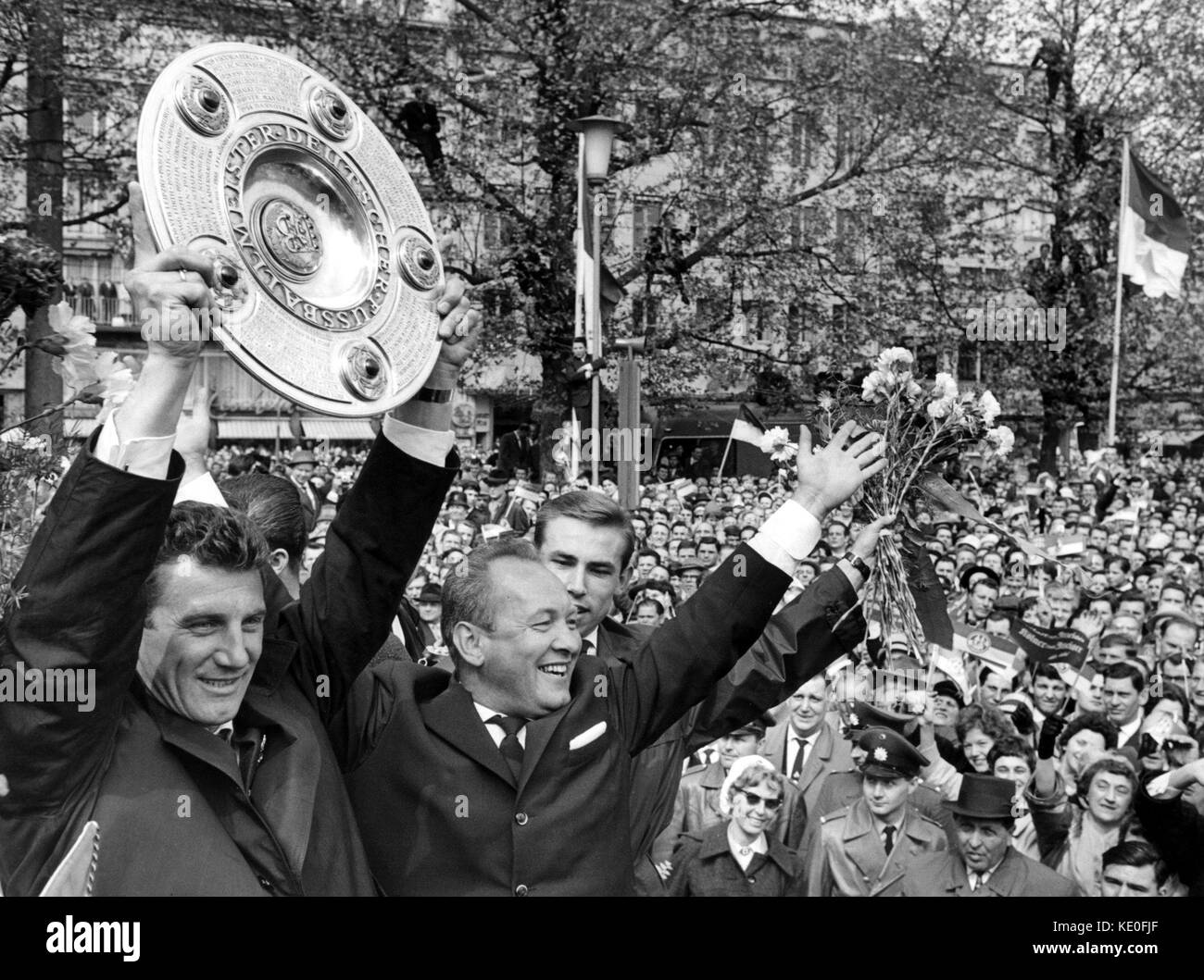 ARCHIVIO - il capitano della squadra di 1. FC Colonia, Hans Schaefer detiene il trofeo tedesco Bundesliga a Colonia, il 13 maggio 1964. Accanto a lui c'è il capo allenatore Zlatko 'Tschik' Cajkovski (2-L) e Fritz Pott. Colonia è stata nominata il primo vincitore della nuova Bundesliga tedesca. Hans Schaefer avrà 90 anni il 19 ottobre 2017. Foto: dpa/dpa Foto Stock