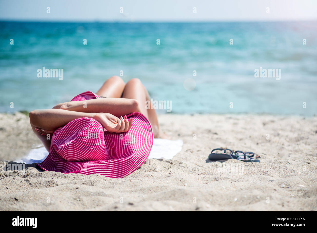 Donna in hat rilassante sulla spiaggia Foto Stock