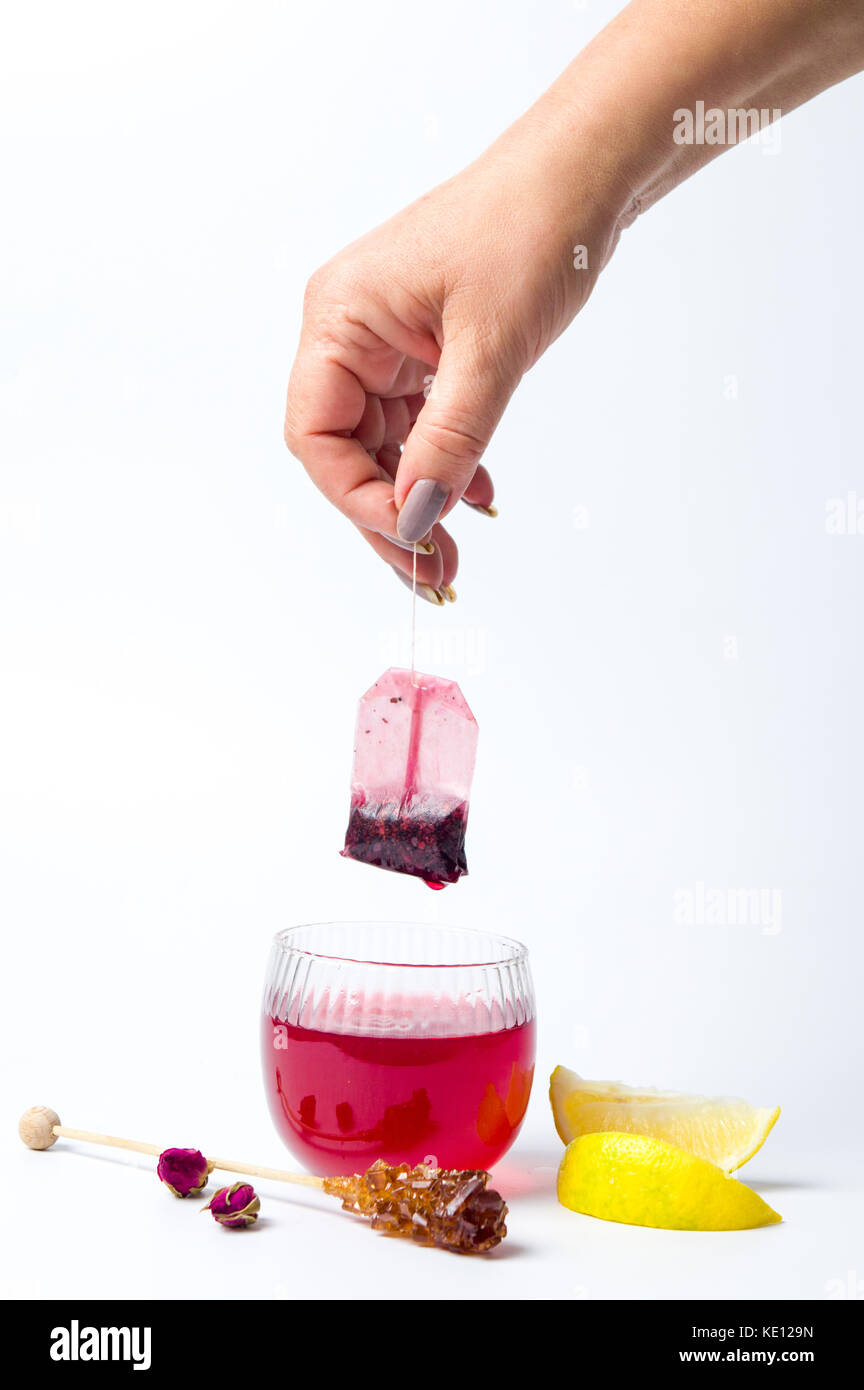 Canto tenuto fuori un sacchetto da tè al di fuori del bicchiere isolato Foto Stock