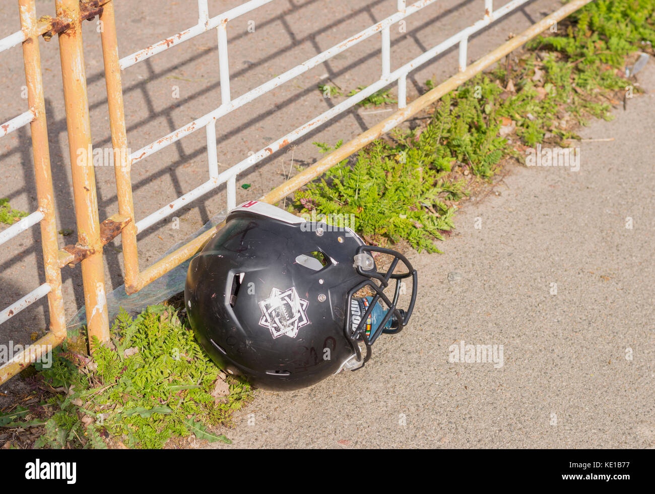 KIEV, UCRAINA - 29 APRILE 2017: Casco da football americano abbandonato giacente a terra nella giornata di sole Foto Stock