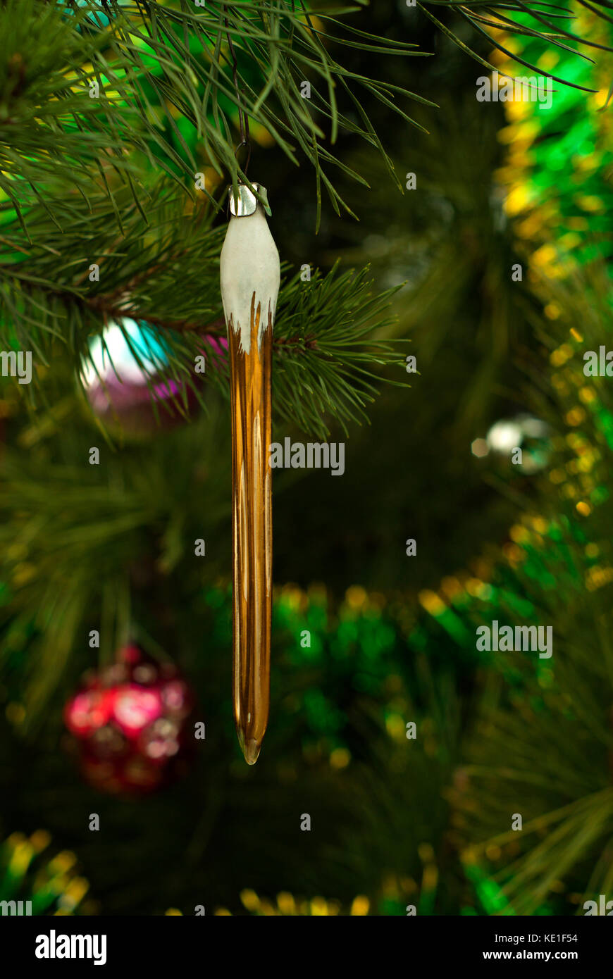 Vetro vintage ornamento di Natale - bronzo o golden ghiacciolo - sullo sfondo di una offuscata albero di natale Foto Stock