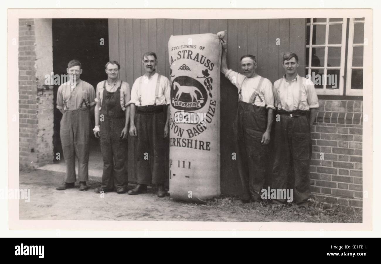 Raccoglitrici di luppolo o di lavoratori con il luppolo imballate in una sacca o "poke', eventualmente in piedi al di fuori del forno di luppolo - Questa foto rappresenta i lavoratori sul Kingston Bagpuize station wagon, vicino a Abingdon, Oxfordshire (in questo momento è stato nella contea del Berkshire). Il giardino di luppolo, era di proprietà del Berkshire Hop Company che hanno comprato i giardini nel 1936 dall'ex proprietario dell immobile, Edward Strauss. Il "poke' ha il cavallo bianco logo e membri in cima 'successors di E.A. Strauss. Foto Stock