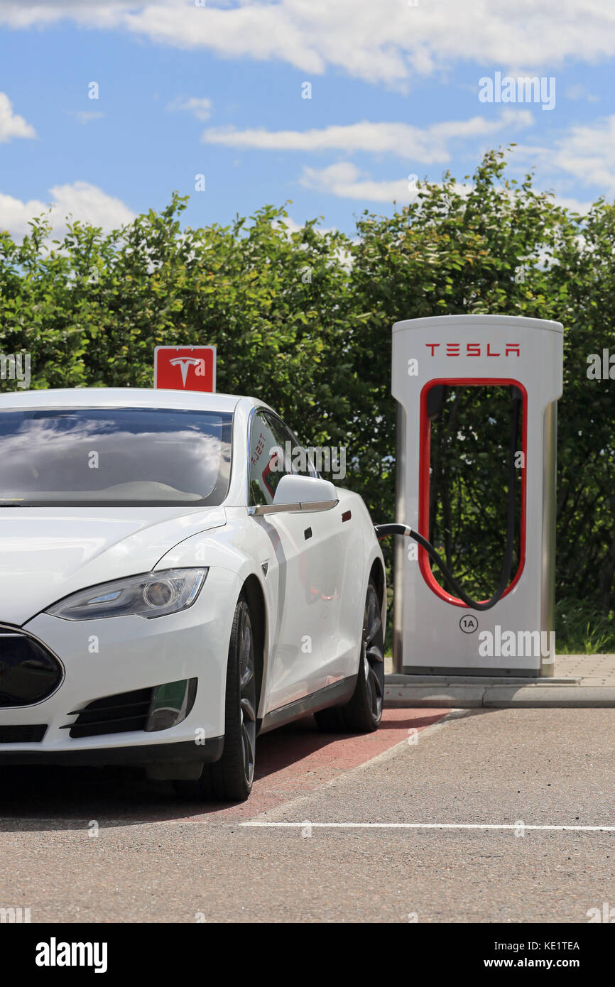 PAIMIO, Finlandia - 4 giugno 2016: Bianco Tesla Model S auto elettrica è in carica di Tesla Supercharger stazione. La carica della batteria da 10 a 80 pe Foto Stock