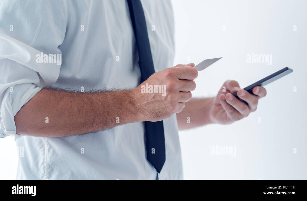 Servizi bancari elettronici con telefono cellulare. imprenditore tenendo lo smartphone e carta di credito, controllo saldo del conto corrente bancario, utilizzando internet online applicazione Foto Stock