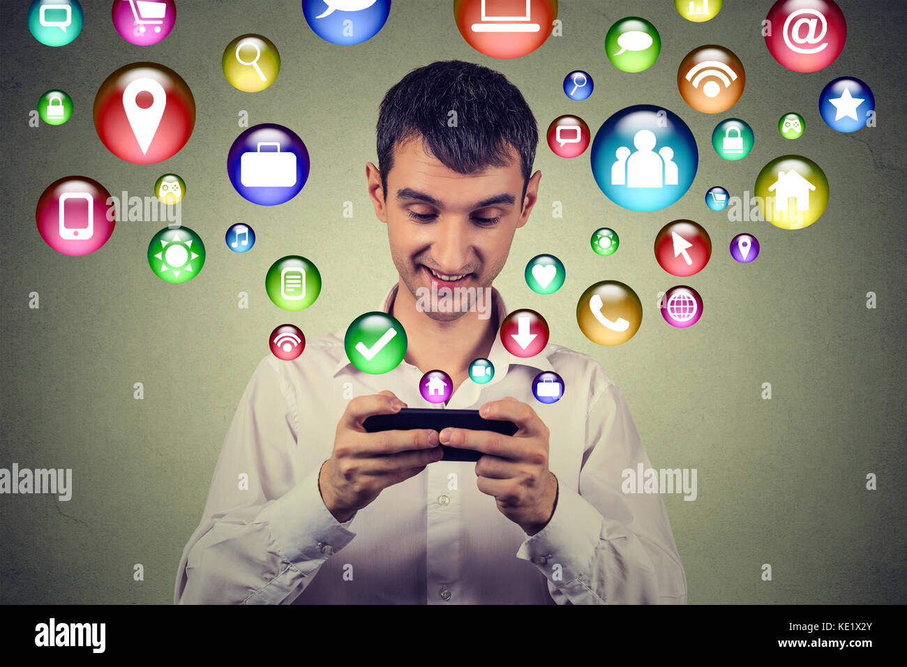 La tecnologia di comunicazione mobile phone high tech concetto. uomo felice utilizzando messaggi di testo sullo smartphone social media le icone delle applicazioni di volare in alto di cellpho Foto Stock