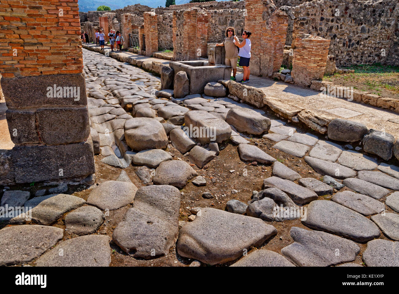 Strada con acqua comunale font con le rovine di una città romana di Pompei a Pompei Scavi, vicino napoli, Italia meridionale. Foto Stock