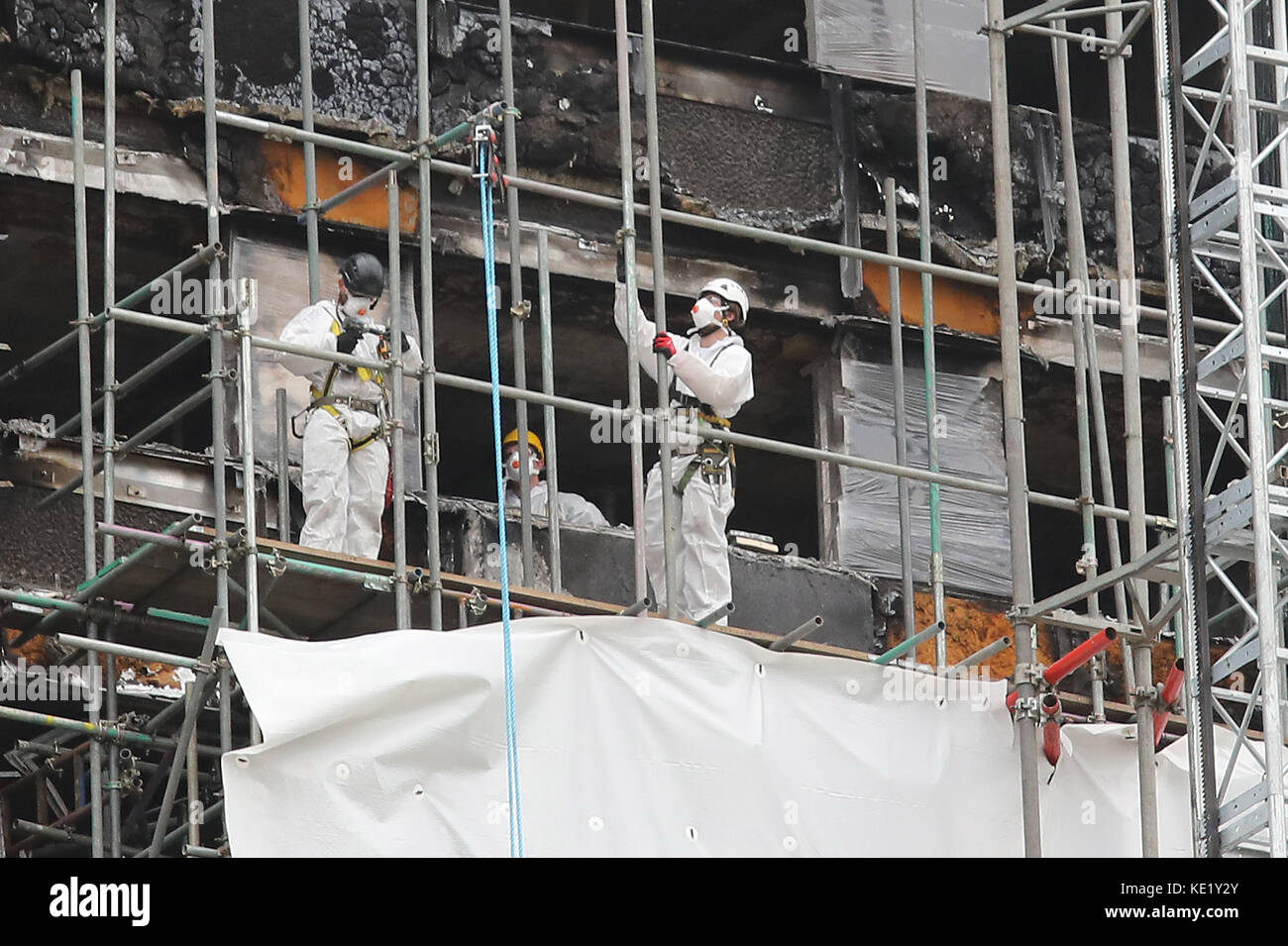 Lavoratori su ponteggi all'esterno della Torre di Grenfell a Londra, quasi quattro mesi da quando un incendio ha inghiottito il blocco. Foto Stock