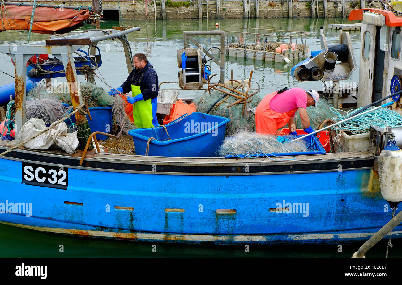 I pescatori operanti sulla barca da pesca deck, West Bay, Dorset, Inghilterra Foto Stock