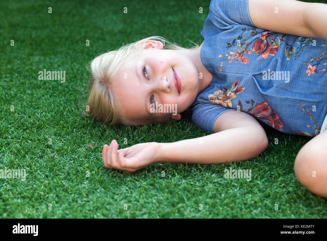 Bambina sdraiati sull'erba in giardino Foto Stock