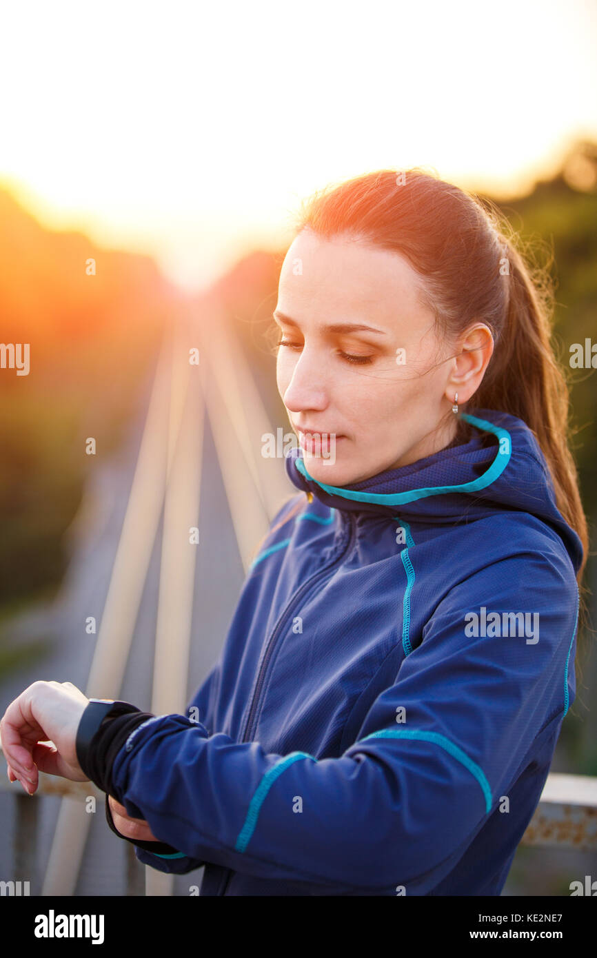 Ritratto di giovane donna sportivo controllando la frequenza cardiaca su orologio fitness. athletic girl outdoor permanente dopo un allenamento fitness Foto Stock