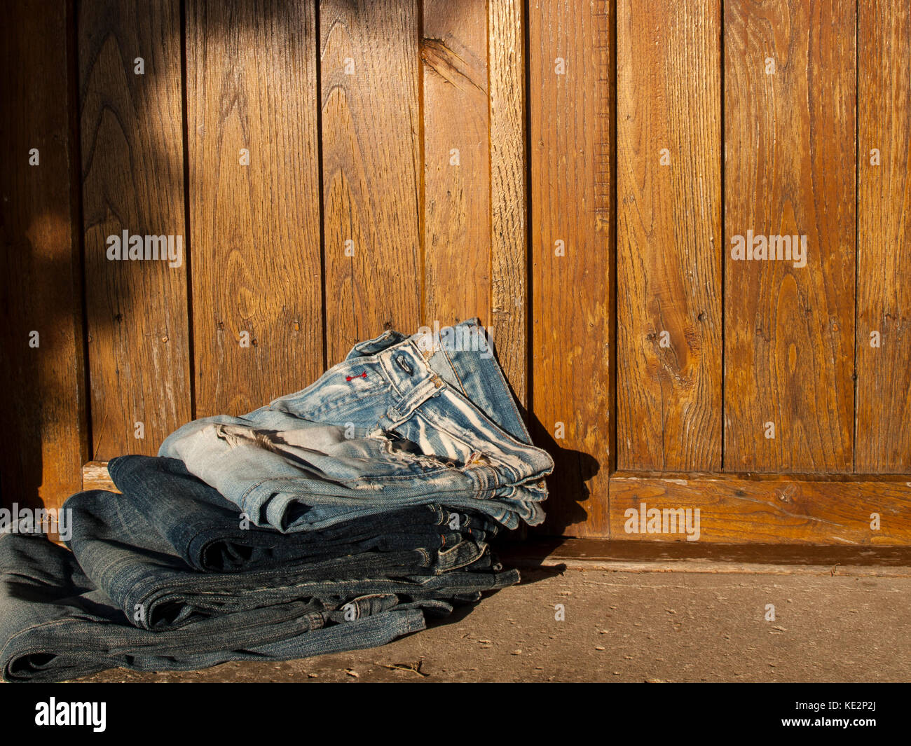 Pila di jeans blu-sfondo di legno Foto Stock