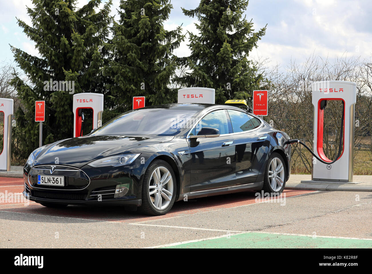 PAIMIO, Finlandia - 29 Aprile 2016: Nero Tesla Model S auto elettrica che opera come un taxi è in carica di Tesla Supercharger stazione di Paimio Foto Stock