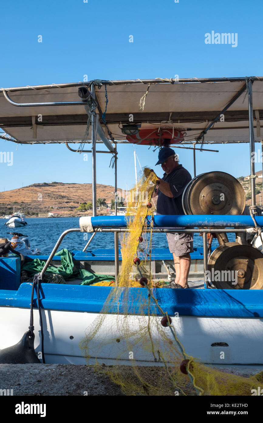 Pescatore greco untangling rete da pesca Foto Stock