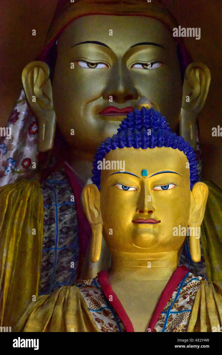 Due statue di Buddha in un monastero buddista in zanskar: il giallo figura alla ribalta, in background è un enorme ed antico figura dorata buddha o Foto Stock