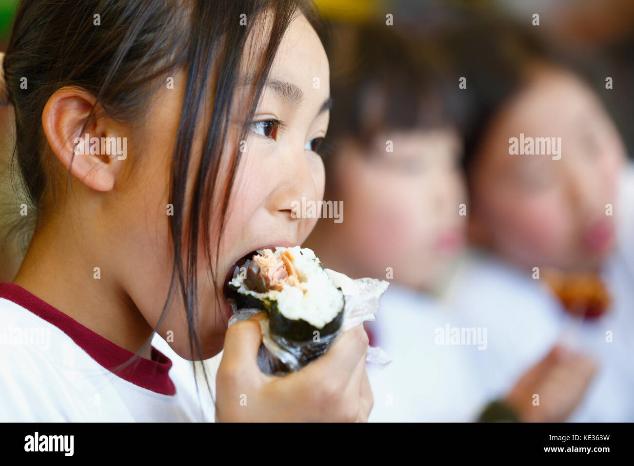 Giapponese scuola elementare kid mangiare in classe Foto Stock