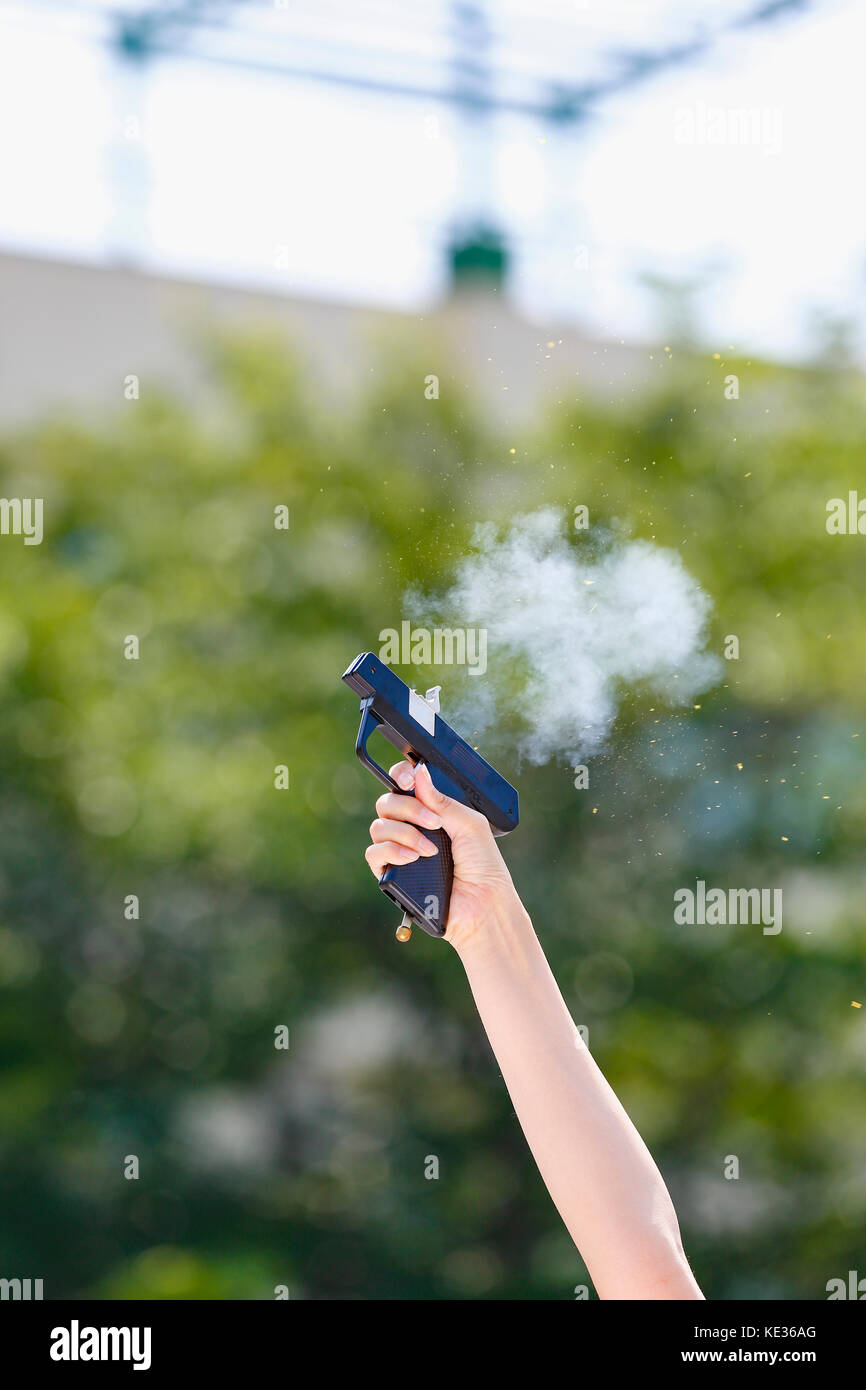 Mano che tiene la pistola di avviamento nel giardino della scuola Foto Stock