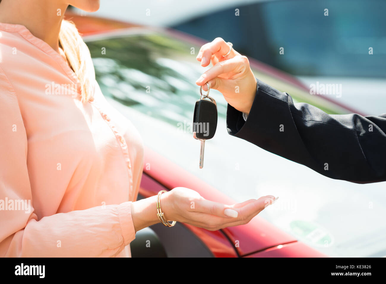 Close-up di un concessionario dando chiave auto per donna Foto Stock