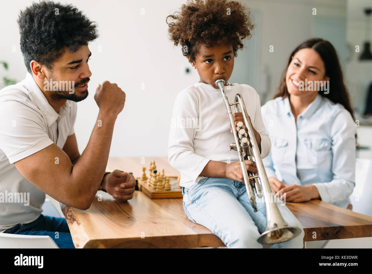 Orgogliosi genitori guardando il loro bambino gioca tromba Foto Stock