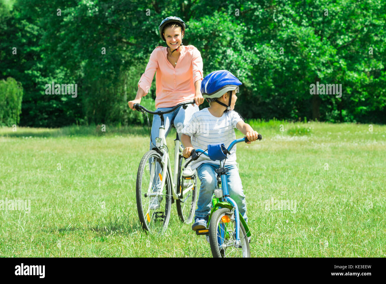 Madre e Figlio godendo il tragitto in bicicletta nel parco Foto Stock